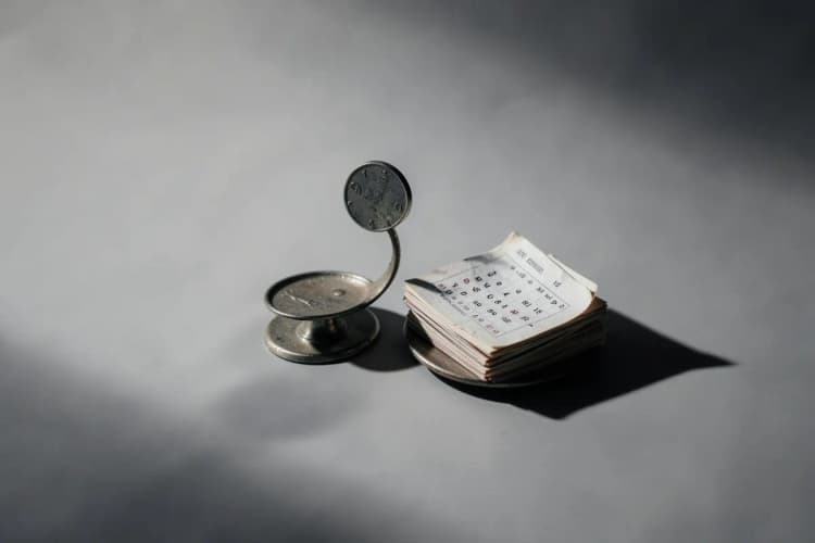 Uma balança com uma moeda de um lado e um calendário do outro, representando o tempo e o valor da contribuição